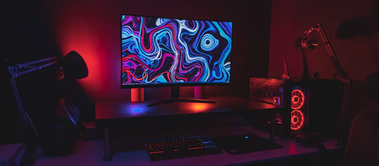 Desktop workstation tower beside a monitor in a dark workspace